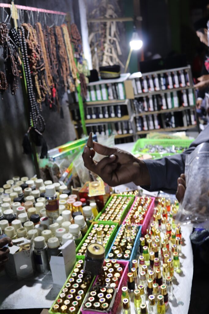 A vendor table with perfume, prayer beads, and agarwood.